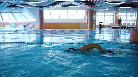 hombre nadando estilo libre en la piscina cubierta