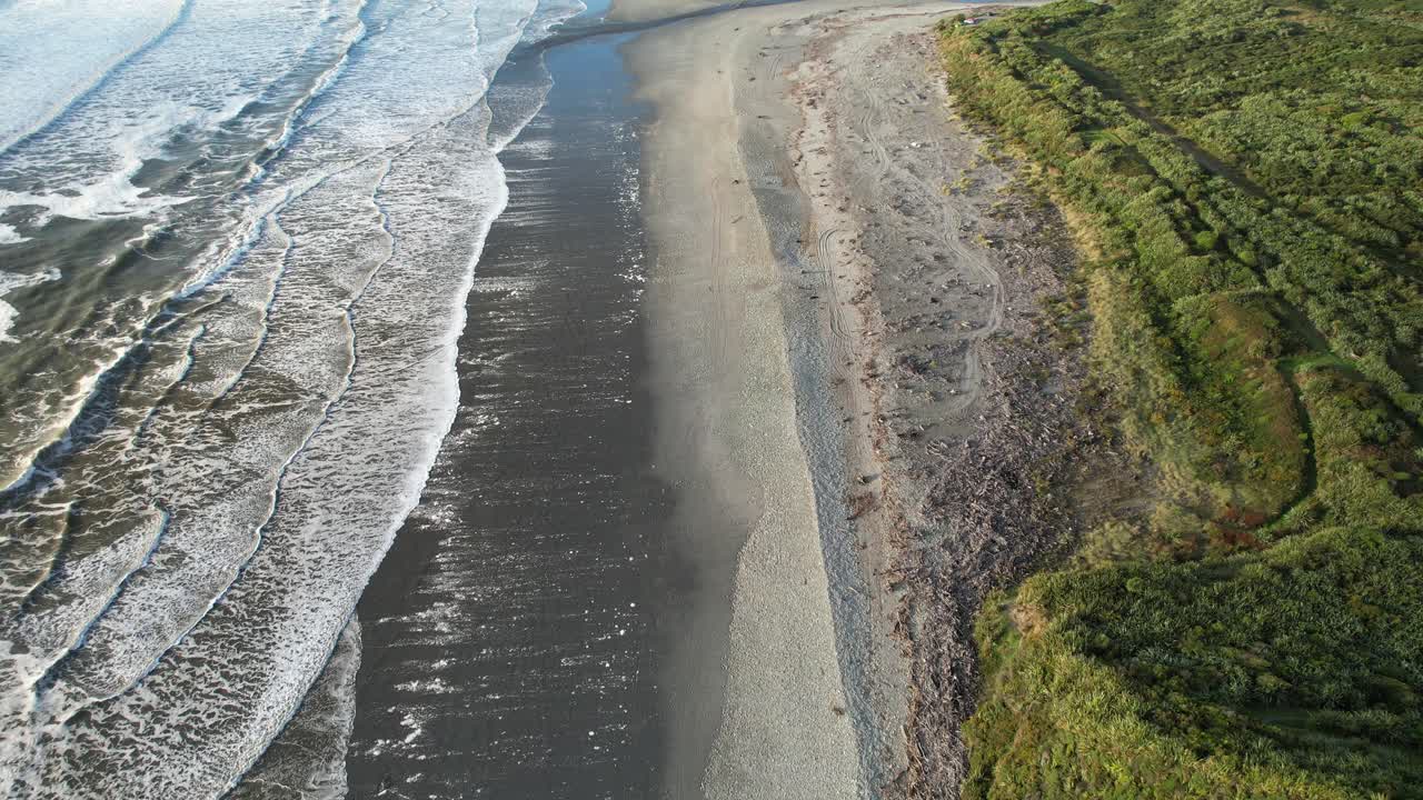 Waves Rolling In Slow Motion Onto Sandy Beach Of Rapahoe With Dense Green Vegetation. Davy Creek Mouth Revealed. aerial tilt-up shot