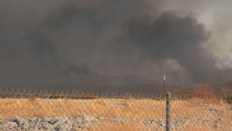 Burnt-out-field-during-a-massive-fire,-smoke-is-rising-into-the-sky-and-creating-a-lot-of-pollution