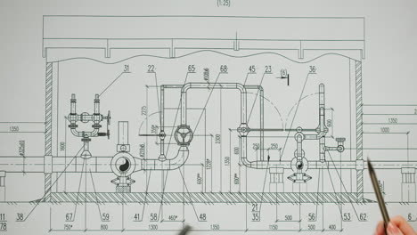 hands pointing at an engineering blueprint of a piping system