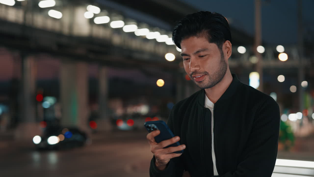 Man looking at phone at night in city