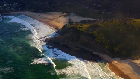 Agua-Turquesa-Y-Olas-Espumosas-Que-Lavan-La-Costa-En-La-Playa-De-La-Era-Norte-En-El-Parque-Nacional-Real,-Nueva-Gales-Del-Sur,-Australia---Toma-Aérea-De-Drones