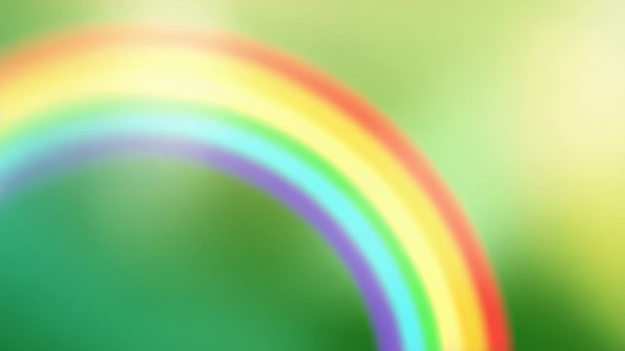 Starting as faint band, rainbow arc adding vivid color over soft-focus green-yellow backdrop