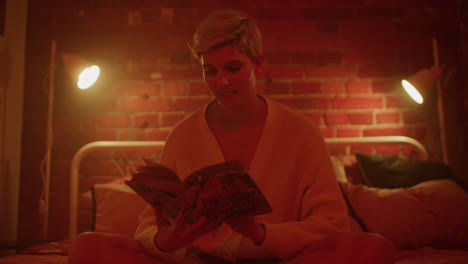 woman reading in a cozy bedroom at night