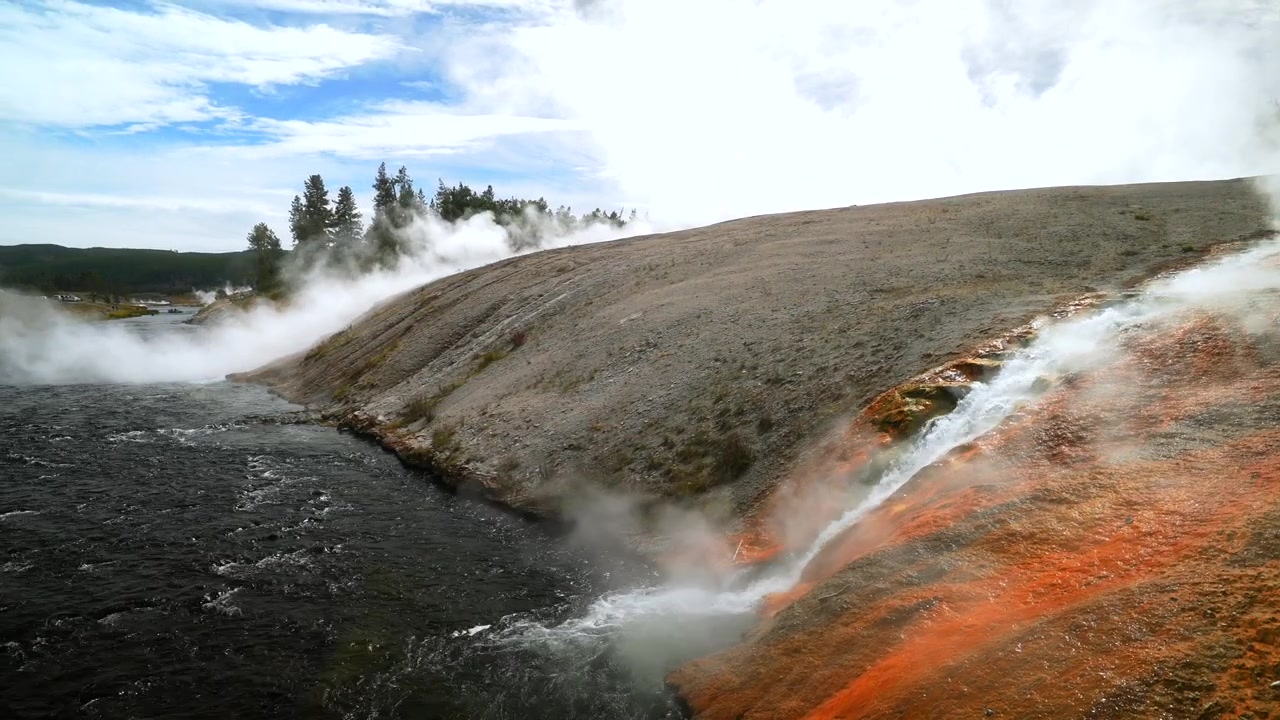 Firehole River, Grand Prismatic Spring, största varma källan med ångande pool i Mid Geyser Basin, Wyoming, USA. Yellowstone nationalparks naturlandskap, Midway Boardwalk vandringsled, solig blå himmel morgon.