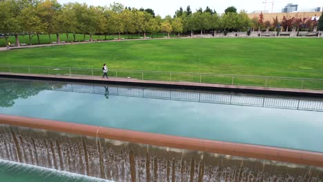 a woman walks near the fountain at bellevue downtown park