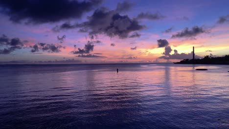 breathtaking purple sunset with silhouette of fisherman in waterfront ocean view