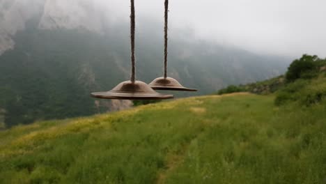 traditional indigenous nomad golden ringing bell hanging in a wooden terrace with beautiful landscape of meadow and fresh mountain in clouds