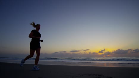 caucasian european female by ocean running at sunrise