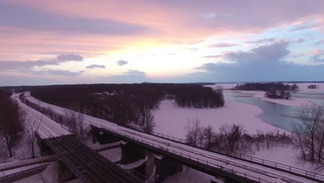 Aerial-flying-shot-of-beautiful-winter-sunset-over-railroads-in-coastal-rural-area