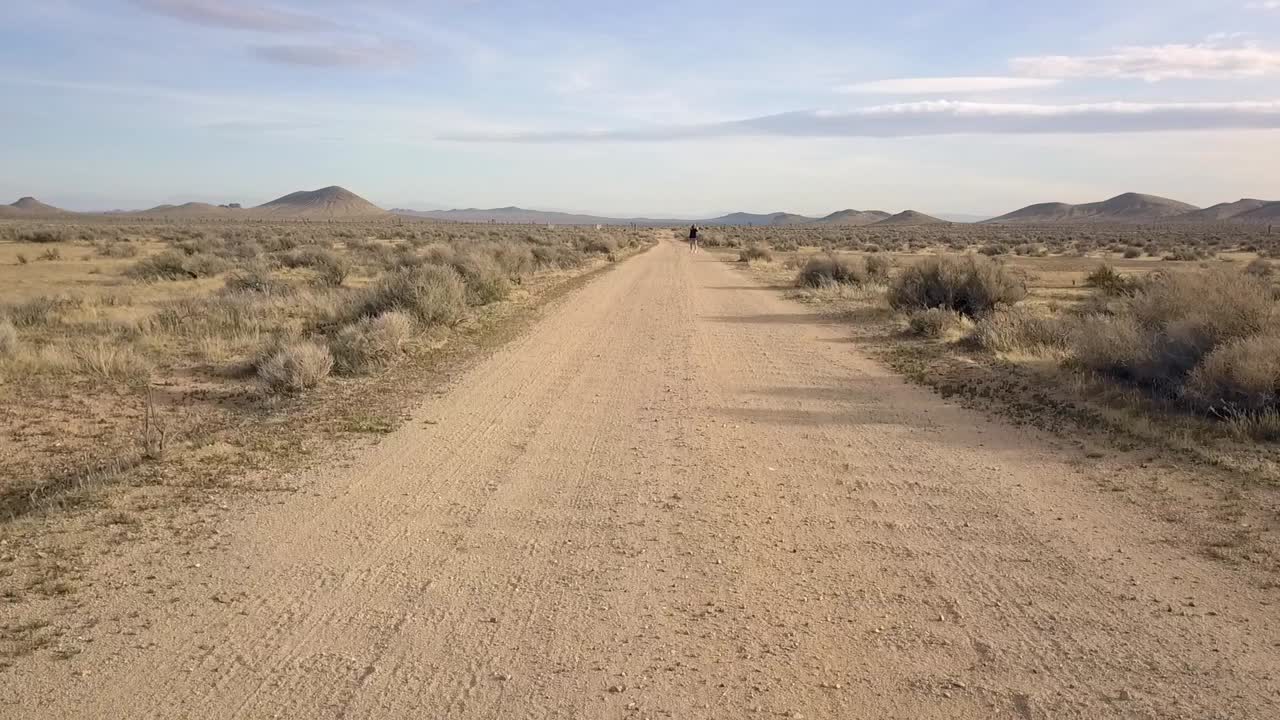 una persona solitaria se encuentra sola en una carretera desierta en el desierto