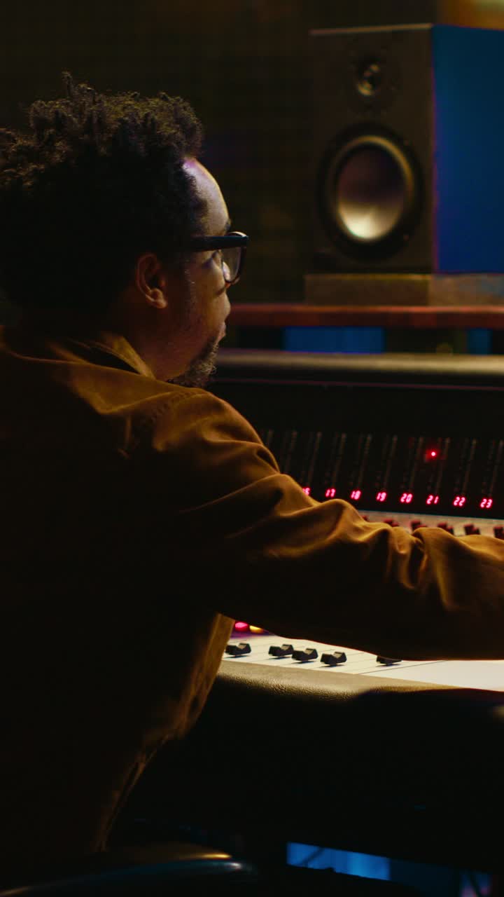 Male Audio Engineer Working on Sound Mixing Console in Studio