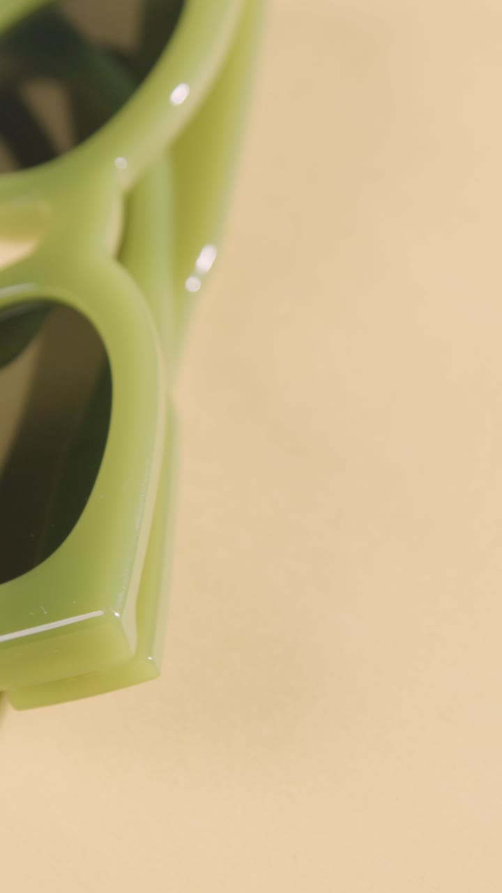 видео вертикальный летний отпуск концепция солнцезащитных очков, вращающихся на желтом фоне