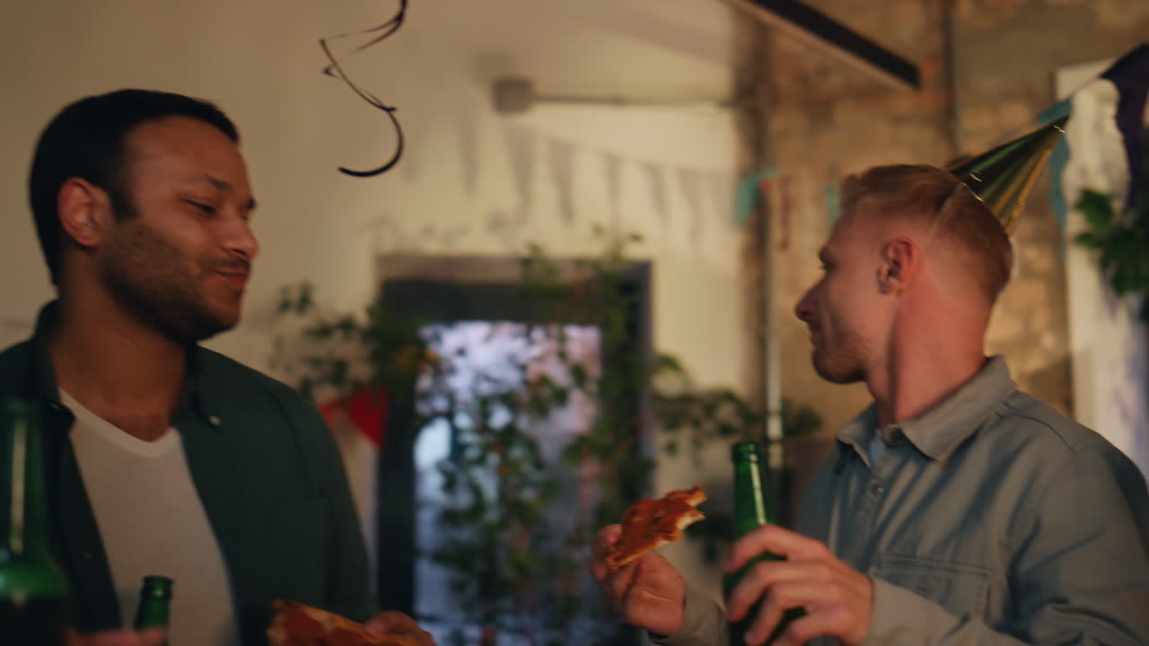 Ungt firma danser til fødselsdagsfest i et rum tæt på. Kolleger hygger sig.