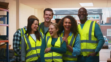 portrait of multi-cultural team wearing hi-vis safety clothing working in modern warehouse