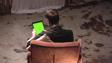 man using tablet with green screen