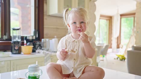 toddler eating breakfast in kitchen