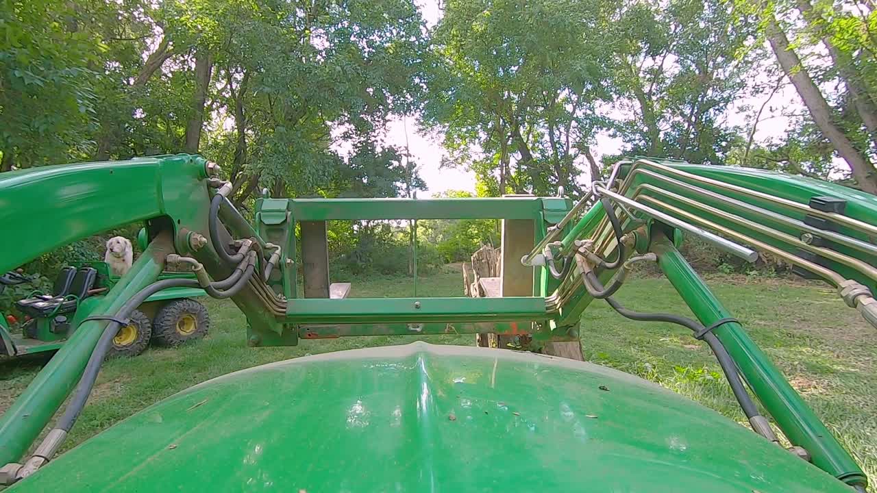 화창한 날 숲 속의 공터에서 포크로 로더를 운전하는 장비 운영자의 pov