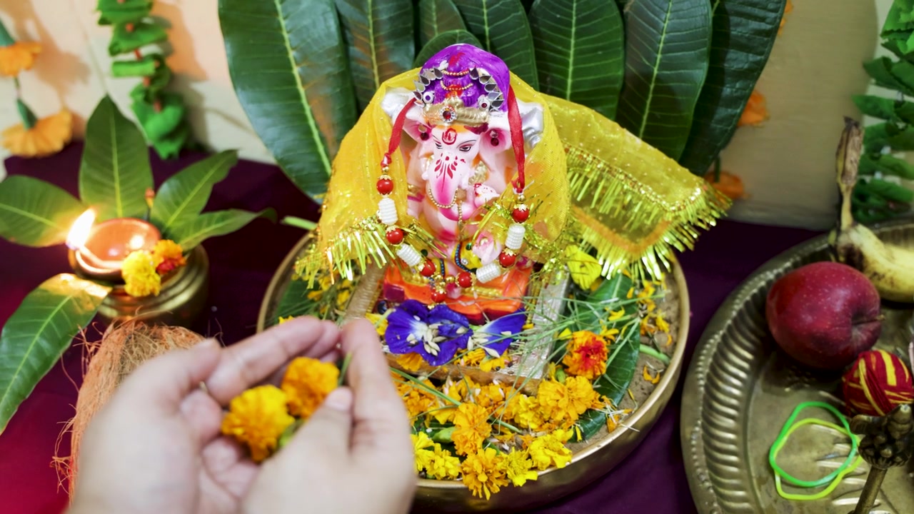 Una donna che celebra un rituale di adorazione di Ganesha nel tempio di casa durante il festival di Ganesh Chaturthi.