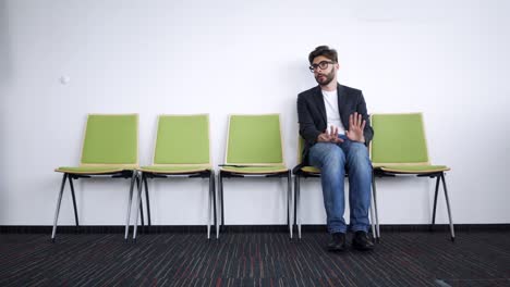 stressed young man sitting in hallway waiting for job interview