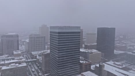 aerial view of downtown salt lake city skyline as snow falls from gloomy sky