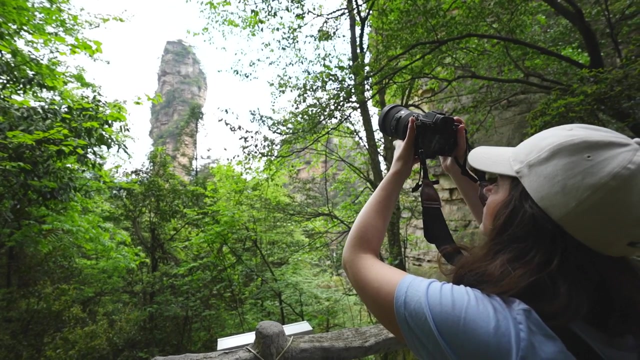 Jovem mulher com uma câmera profissional capturando a maravilha natural de Huangshi Village na China.
