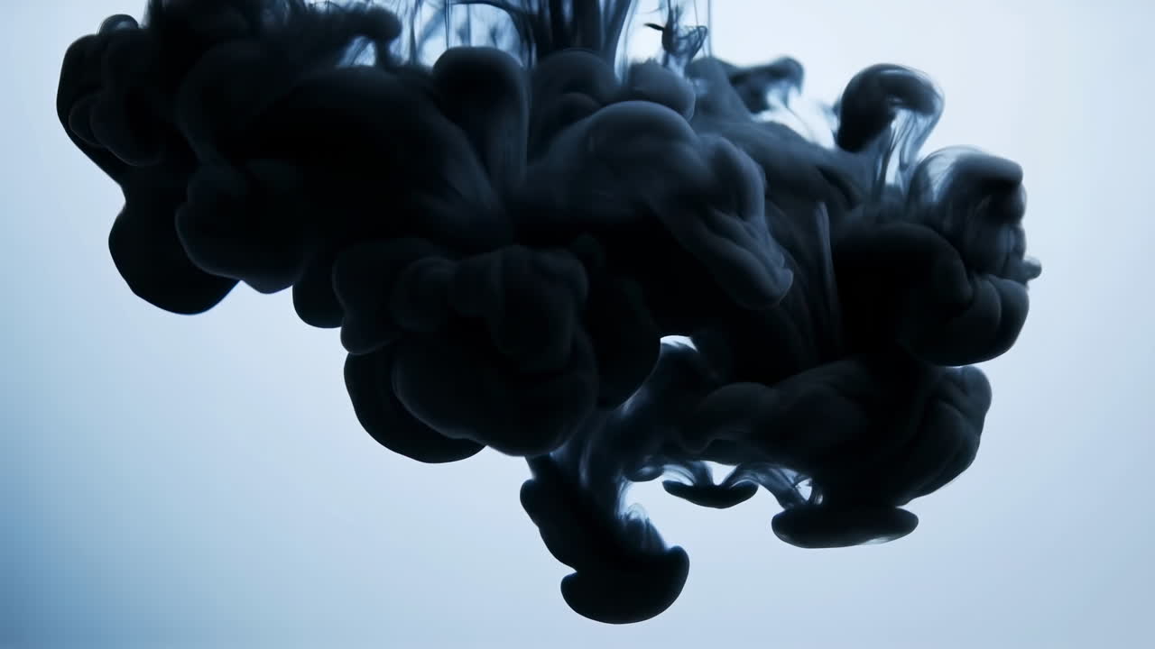 Mørk blæksky i vand, slowmotion-optagelse af sort farvestof, der hvirvler ind i lyseblå væske, bølgende folder