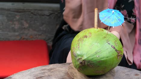 mujer bebiendo agua de coco