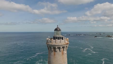 Flying-backwards-aerial-view-of-Phare-du-Four-a-lighthouse-in-Bretagne-France