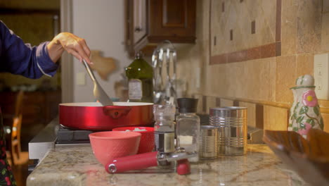 el deslizador revela a la mujer moviendo la comida cocinando en una sartén en la estufa