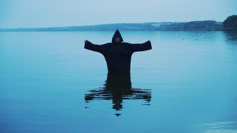 evil witch in a black hood in the river