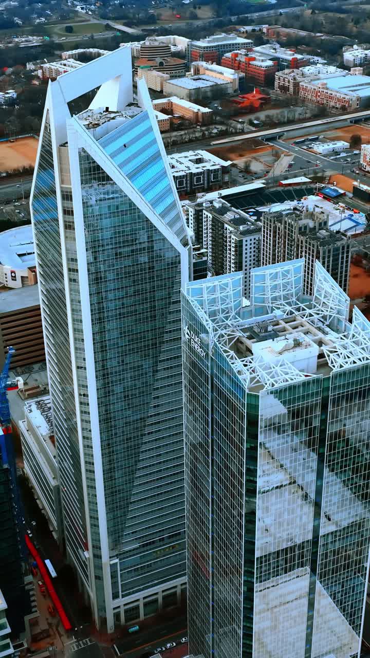 Rascacielos con fachadas de espejo en la zona alta de una ciudad moderna. Perspectiva aérea de Charlotte, NC, EE. UU. Video vertical.