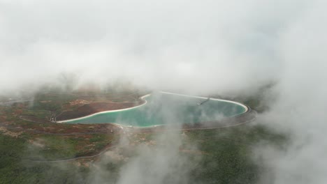 magical mist around blue fresh water reservoir in mountains, aerial