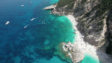 Aerial-drone-video-of-tropical-paradise-turquoise-coast-in-the-mediterranean,-Sardinia-with-boats