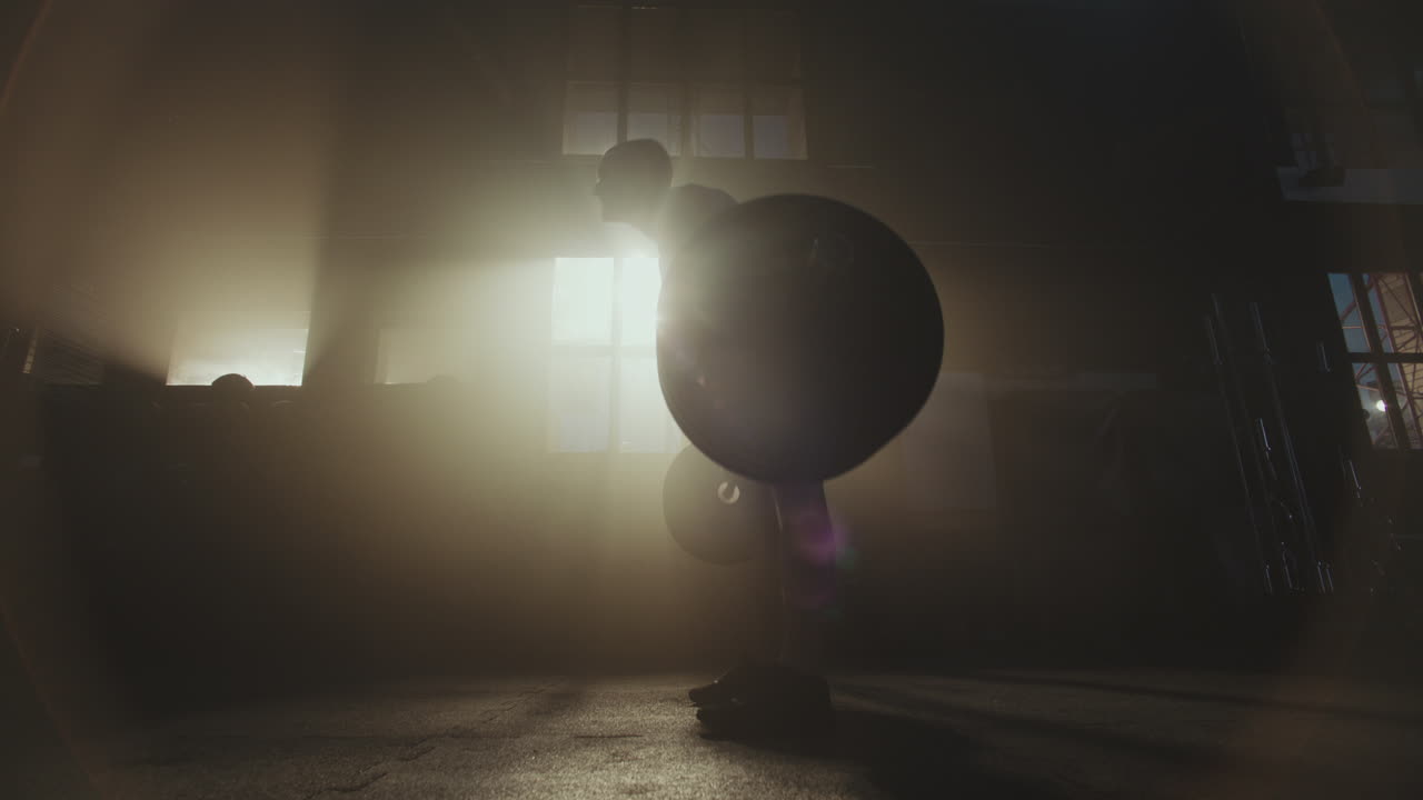 Man Performing a Weightlifting Exercise in a Gym