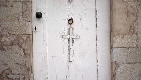 Puerta-Blanca-Envejecida-Con-Cruz-De-Edificio-De-Piedra.