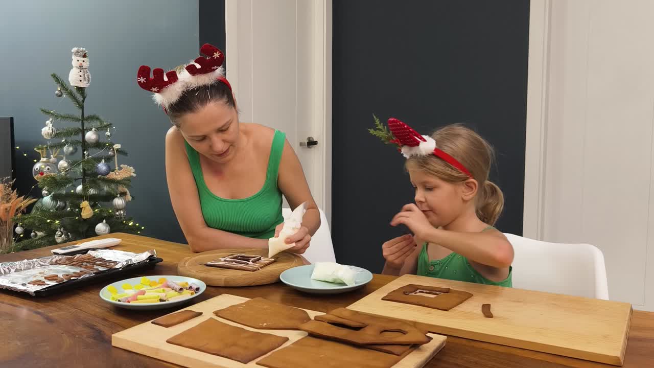 madre y hija decorando casas de pan de jengibre