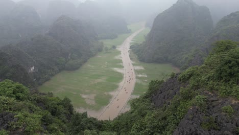 aerial view of boats on a river in the foggy karst mountains of vietnam