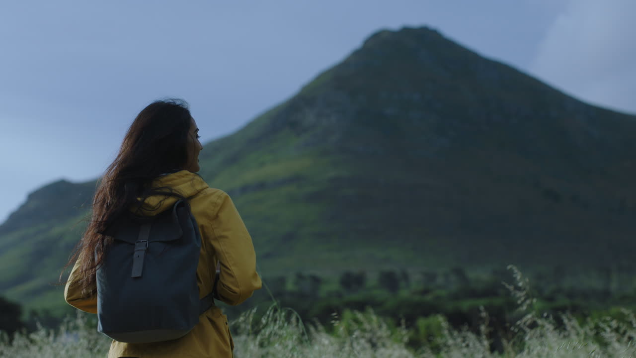 mujer joven india caminando disfrutando de la calma paisaje de montaña pintoresco viento soplando el cabello turista independiente mujer en viaje de aventura