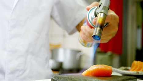 chef masculino calentando sushi en la cocina 4k