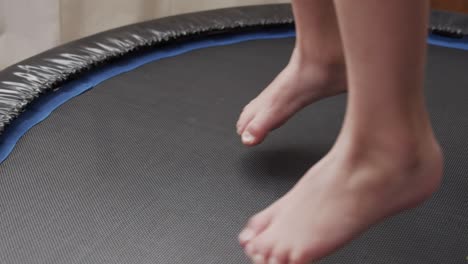 Young-boy-jumping-on-small-trampoline-barefoot-in-slow-motion