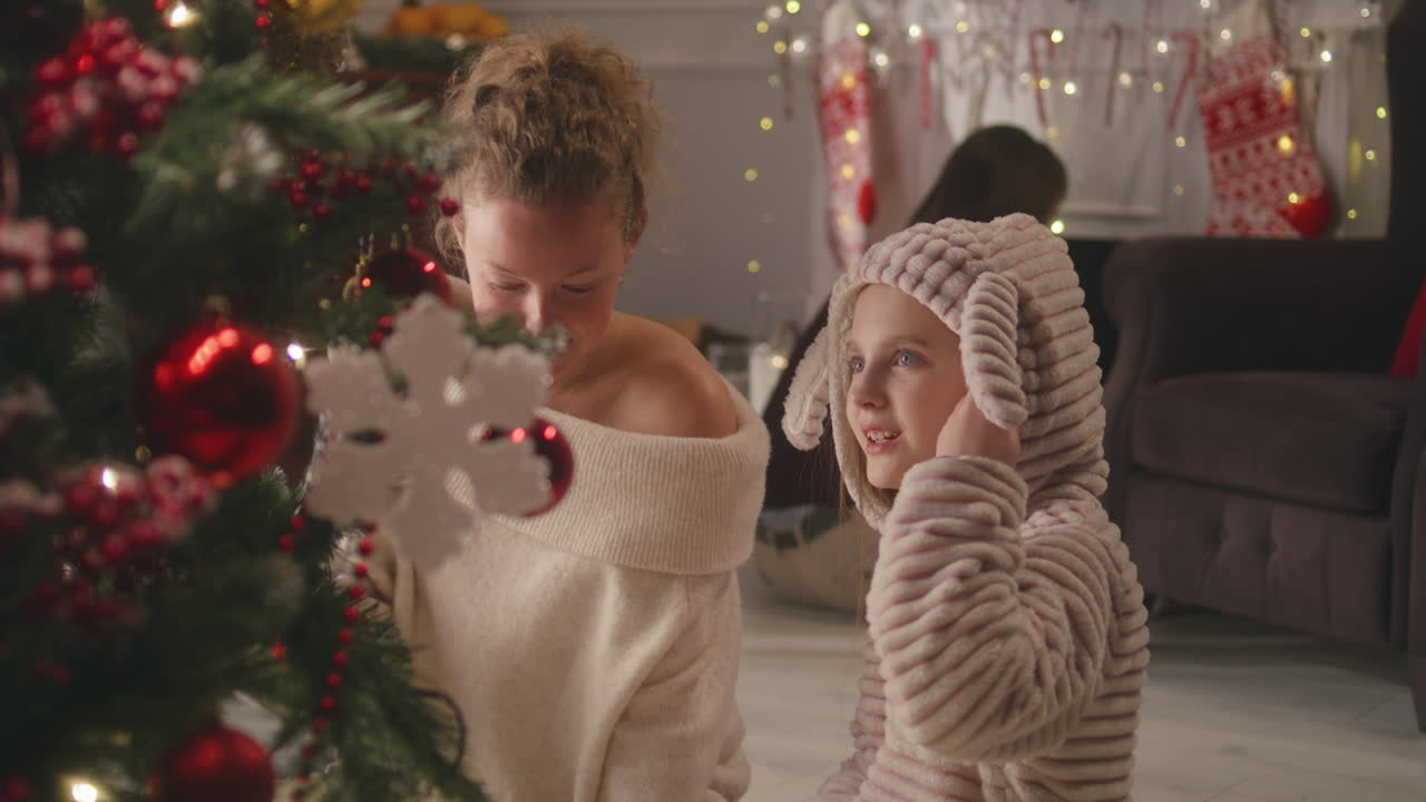 madre e hija decorando el árbol de Navidad