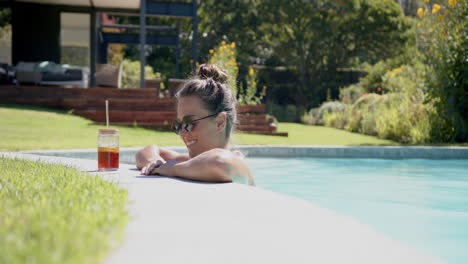 relaxing in pool, woman wearing sunglasses enjoying drink on sunny day