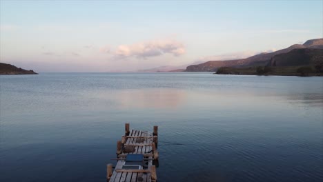 Spectacular-aerial-view-flying-over-old-wooden-pier-coastal-bay