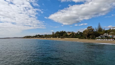 4k-Wide-shot-of-an-empty-beach-at-the-beautiful-luxury-and-exclusive-area-of-Marbella,-Spain