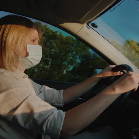 Driver-in-protective-mask-drives-behind-the-wheel-of-a-car