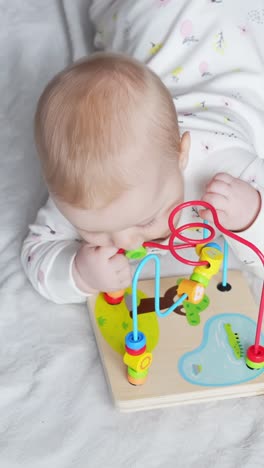 beautiful baby girl playing on bed, vertical close up view