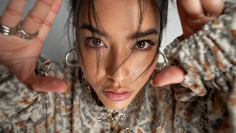 young fashion model posing with hands near face in slow motion