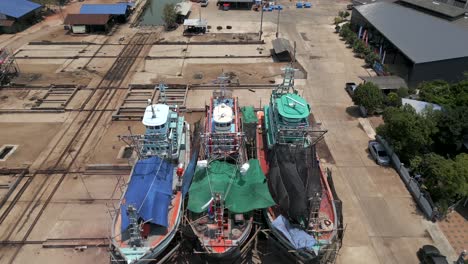 aerial view of fishing boats and a boatyard at a southeast asian port