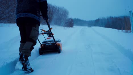 a man is using a snow blower to clear the road - static shot